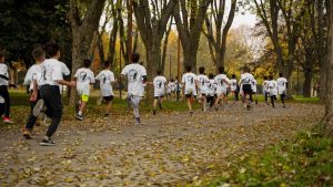 A group of kids participating in a running event in a leafy park in Bursa, Türkiye.